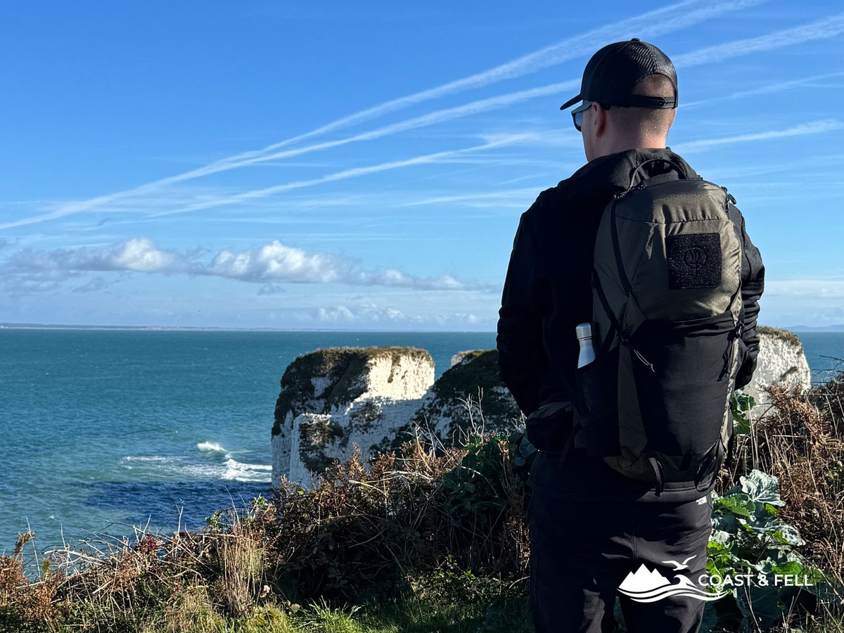The ThruDark Pinnacle 28 in Olive Green worn on the clifftop above Old Harry Rocks, water bottle in the stretch mesh side pocket