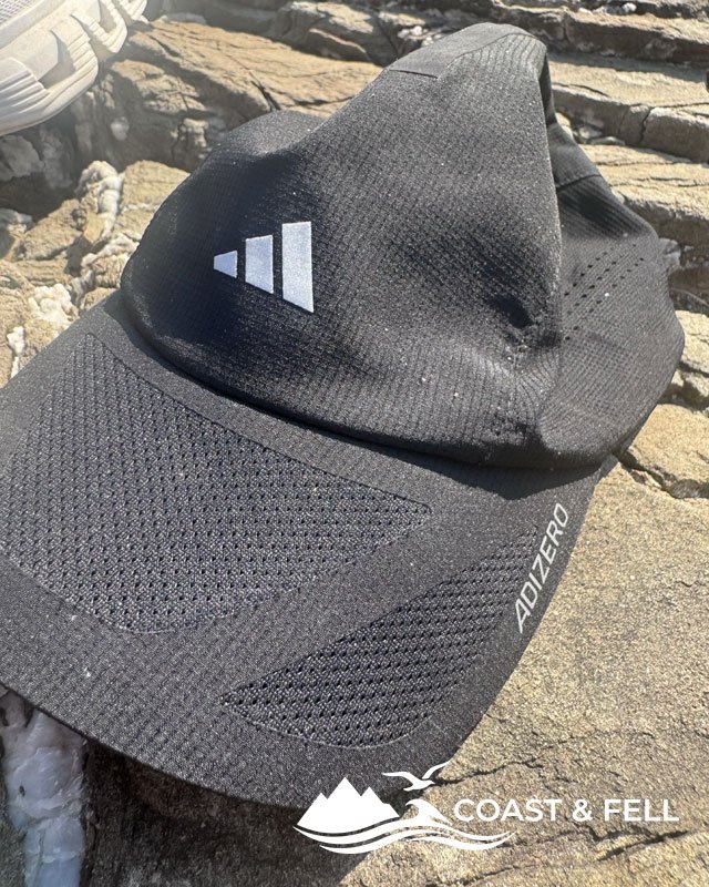 Adidas Adizero Climacool running cap in black, lightweight ventilated mesh, on the rocks in Rhodes