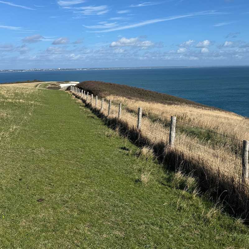 The grassy ridge path along Ballard Down with Poole and Bournemouth across the water