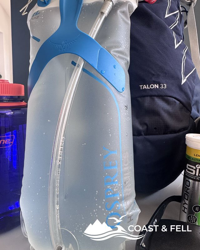 Osprey Hydraulics 3L reservoir filled and fitted into a daypack with the hose routed over the shoulder