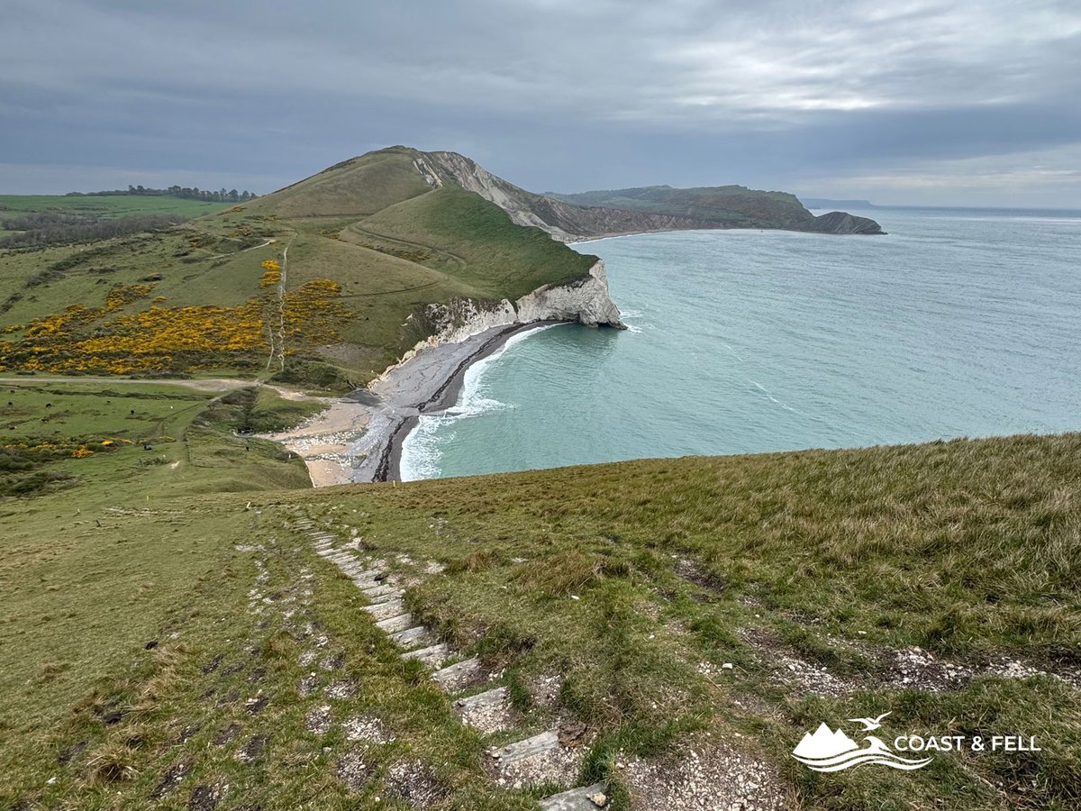 Coast path descending from Hambury Tout toward Man o' War Bay with Durdle Door visible