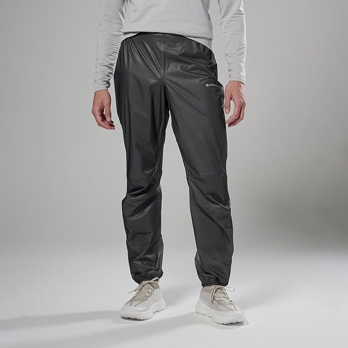 Montane Minimus waterproof pants in black packed into stuff sack showing ultralight construction