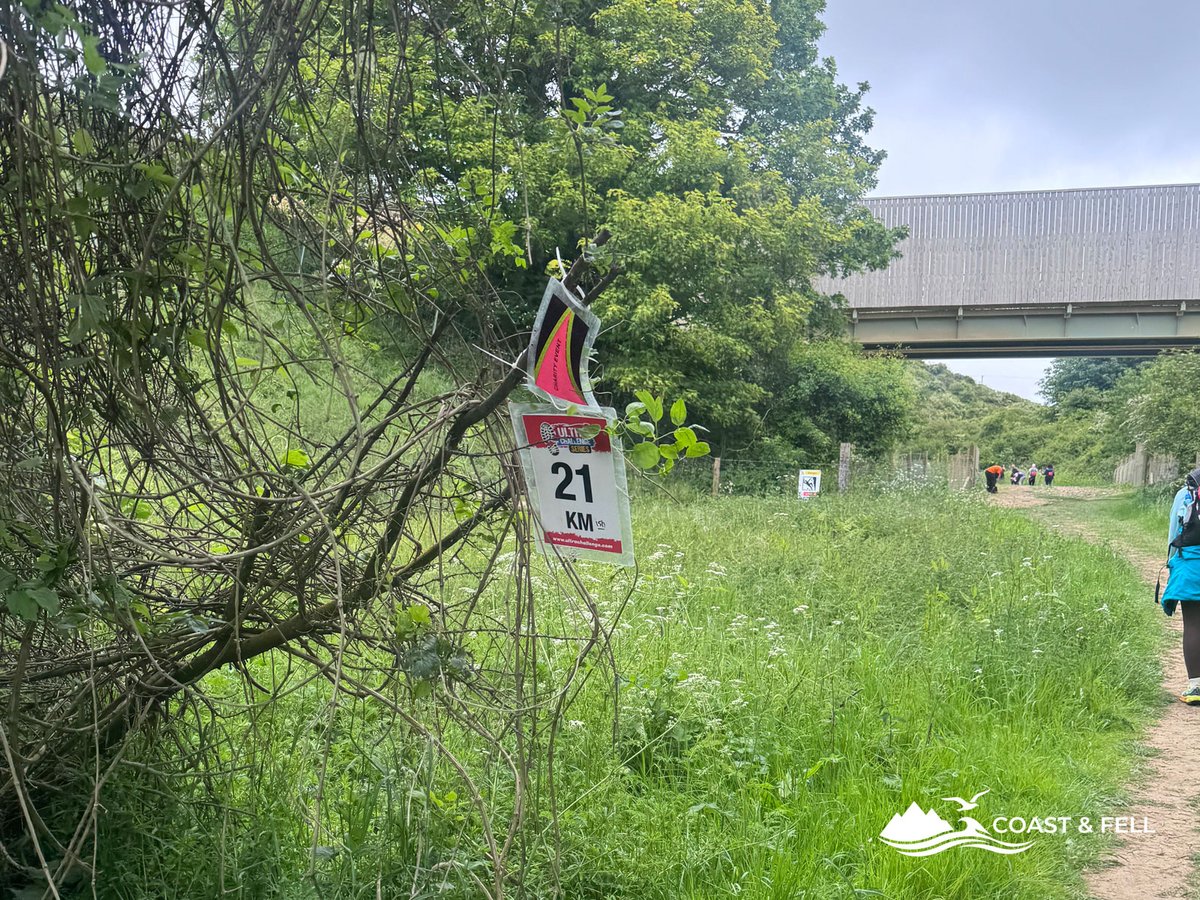 21km distance marker sign for Ultra Challenge Series on hedge with path continuing beyond