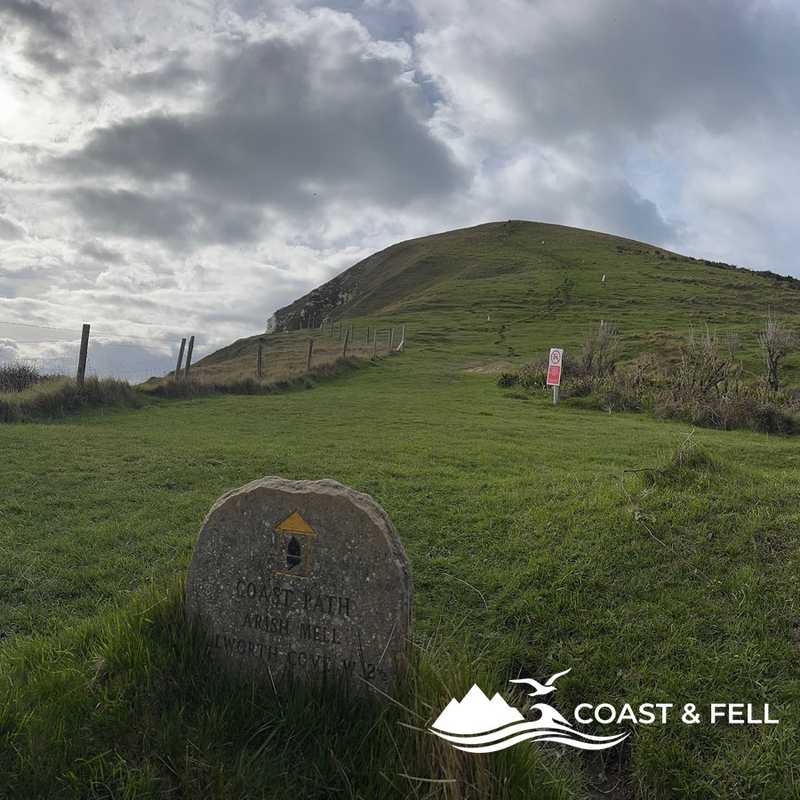 Coast Path waymarker stone pointing to Arish Mell with Bindon Hill behind, Lulworth Ranges, Dorset