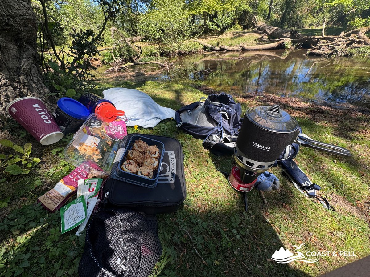 Fire Maple camping stove, Costa coffee cup, sushi lunch and Osprey pack laid out beside the Ober Water